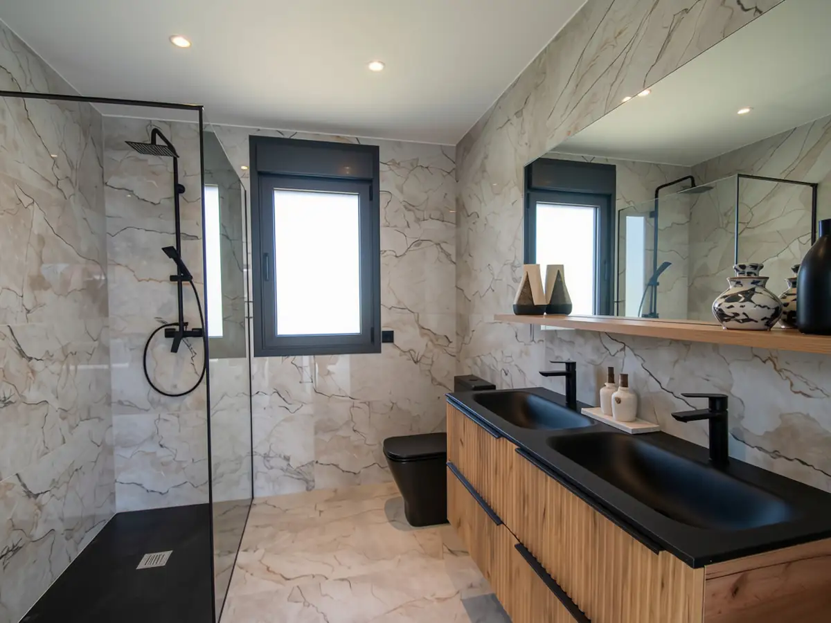 Baño con ducha abierta y doble lavabo sobre mueble de madera en Urbanización La Solana