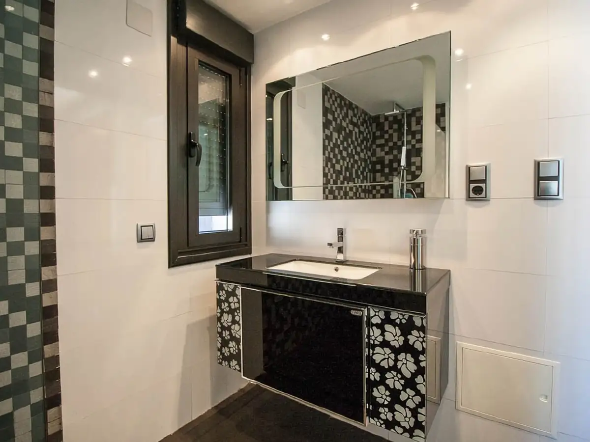 Baño con mosaico en blanco y negro en Edificio Rasán