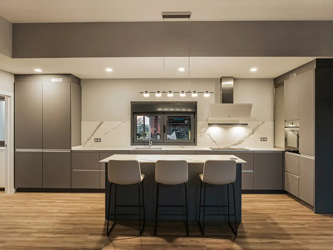 Cocina con isla y encimera de mármol en vivienda Tiroco, Valdesoto