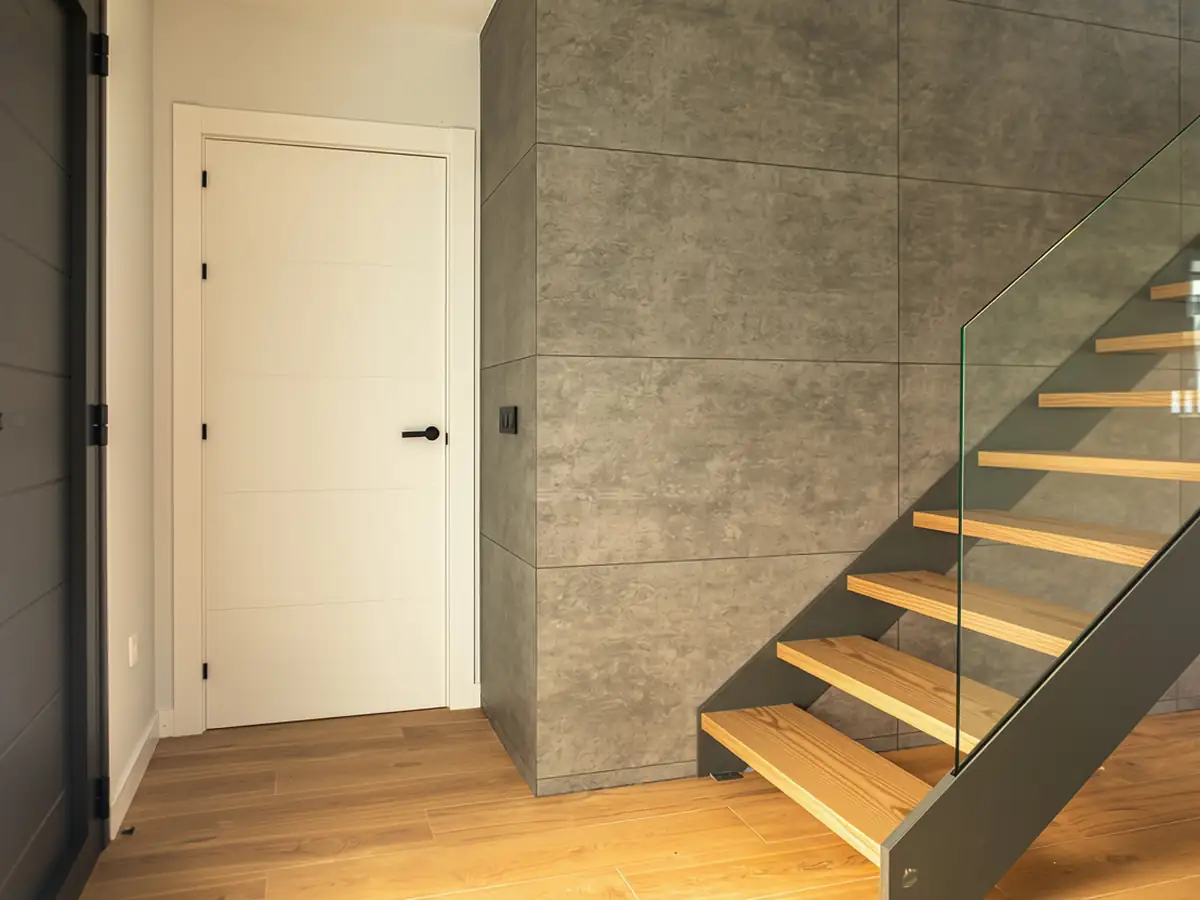 Escalera con peldaños de madera y revestimiento de hormigón en Urbanización La Solana